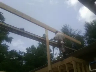 Carpenter setting a ridge beam over a new addition frame — Ice Dam Removal by Roofing Brothers in West Hartland