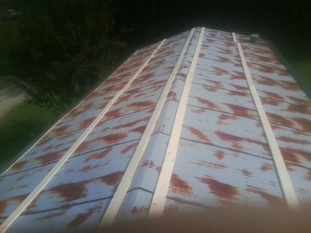 Rusted metal roof panels with new wood purlins before replacement — Storm Damage Roof Repair in West Hartland by Roofing Brothers
